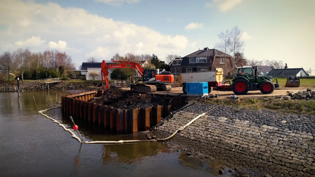 Tractor and excavator working by water side