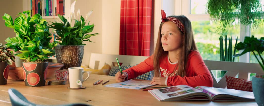 Girl sitting at table drawing