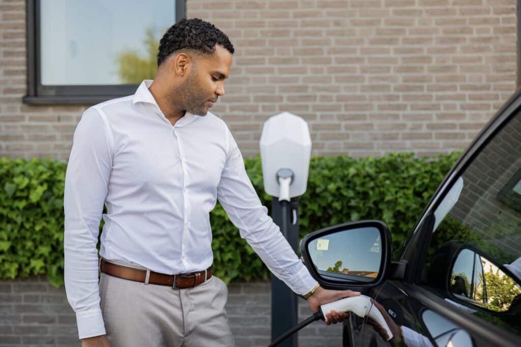 Man charging electric car with Volttime charger