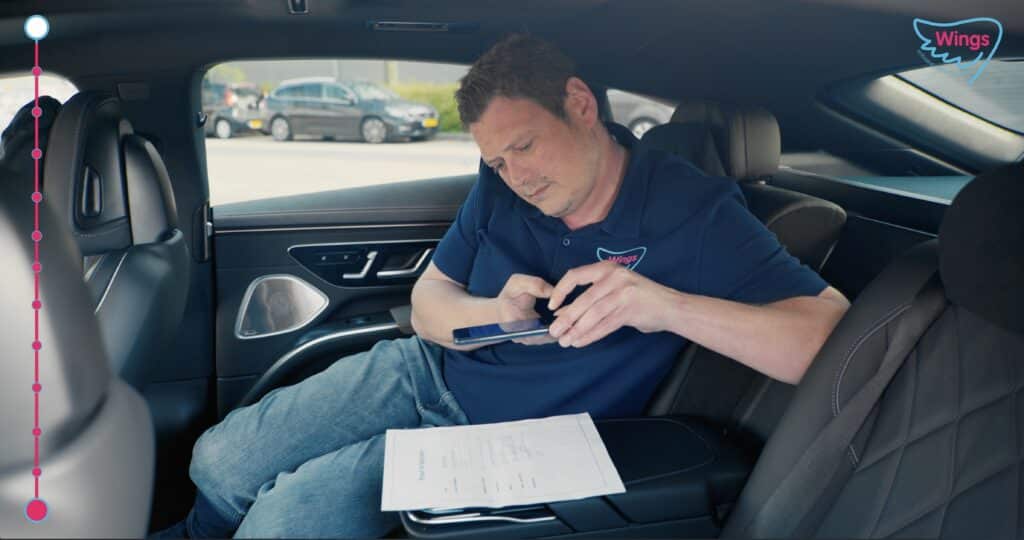 Man in car taking pictures of document