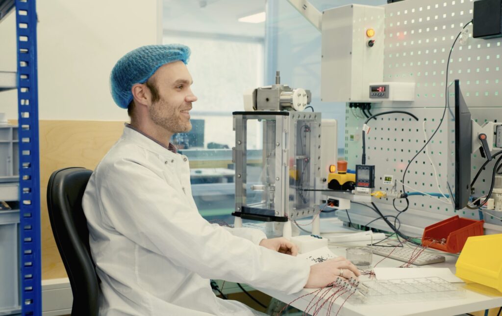 Man wearing labcoat working on a computer