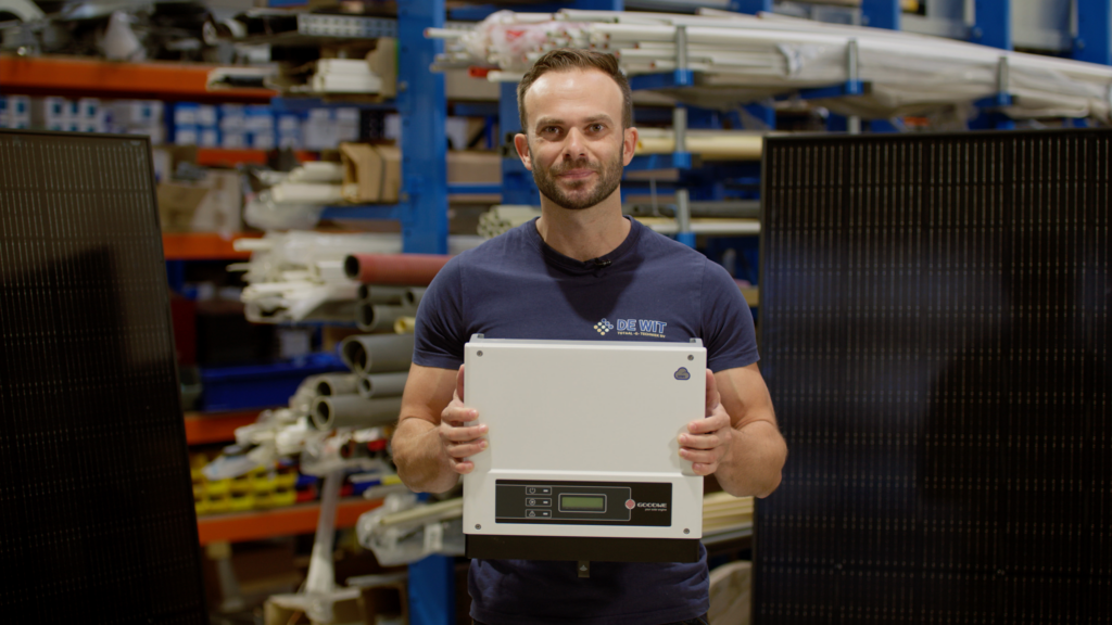 Man holding device with solar panels behind him