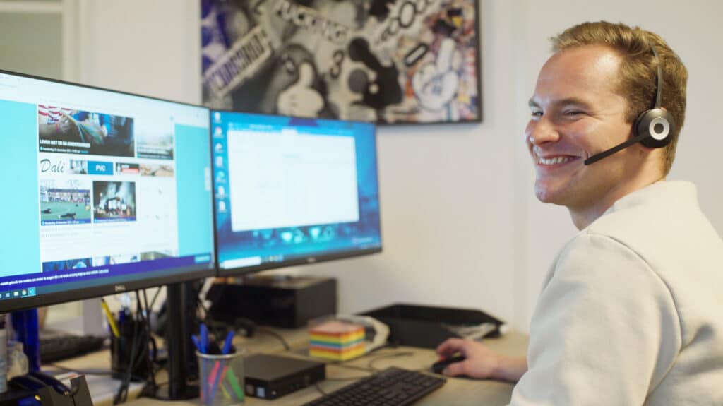 XYTO employee sitting at desk with headset on